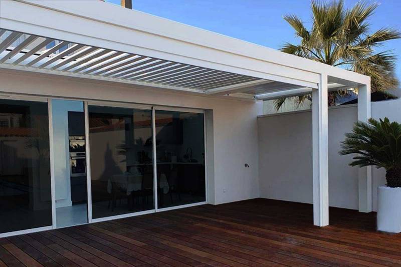 Terrasse moderne avec une pergola bioclimatique sur-mesure en aluminium blanc, installée dans une villa à Draguignan.